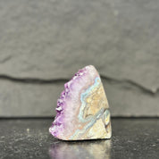 Geode with purple and beige colors on a dark surface