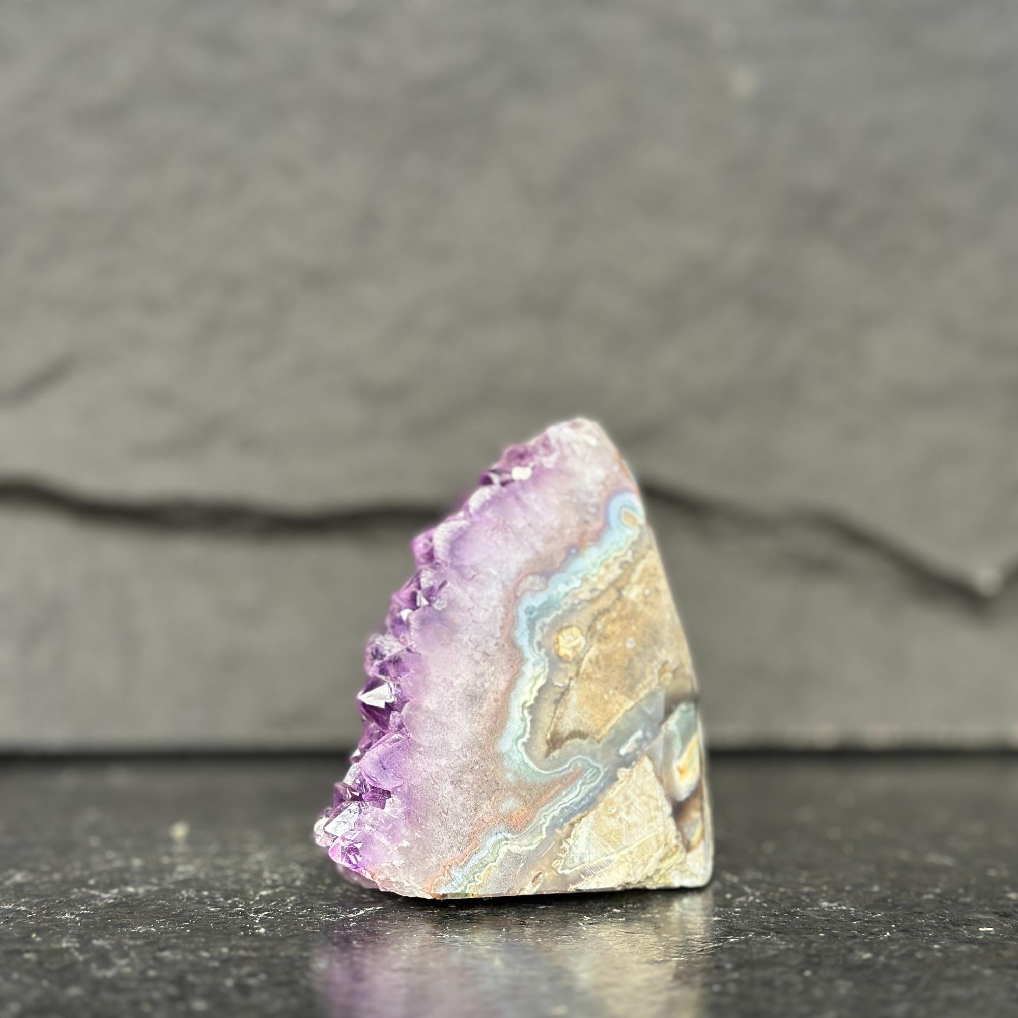 Geode with purple and beige colors on a dark surface