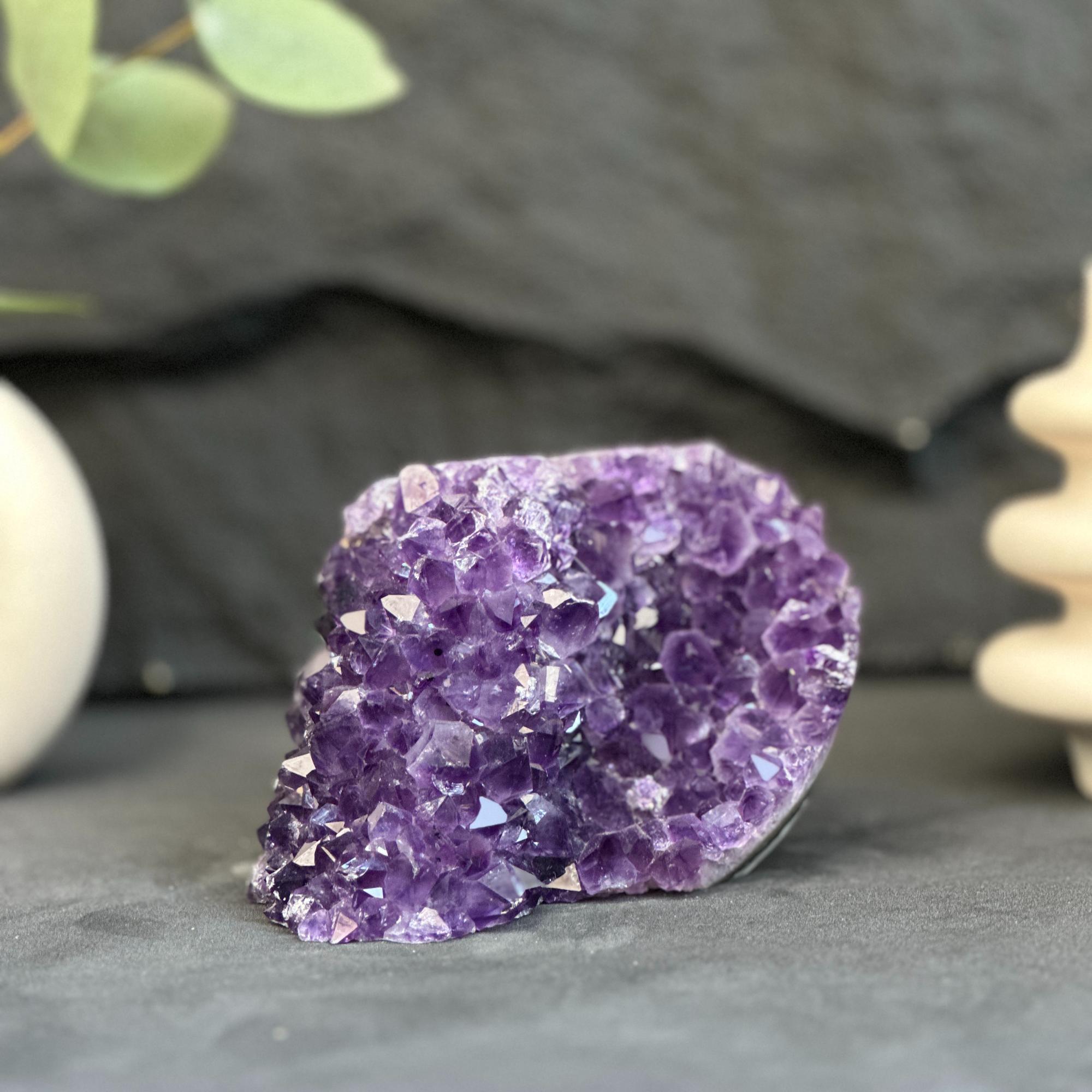 Amethyst crystal on a dark surface with blurred background