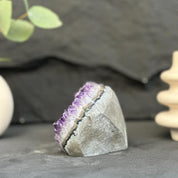 Amethyst crystal on a dark surface with blurred background