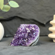 Amethyst crystal on a dark surface with a blurred background