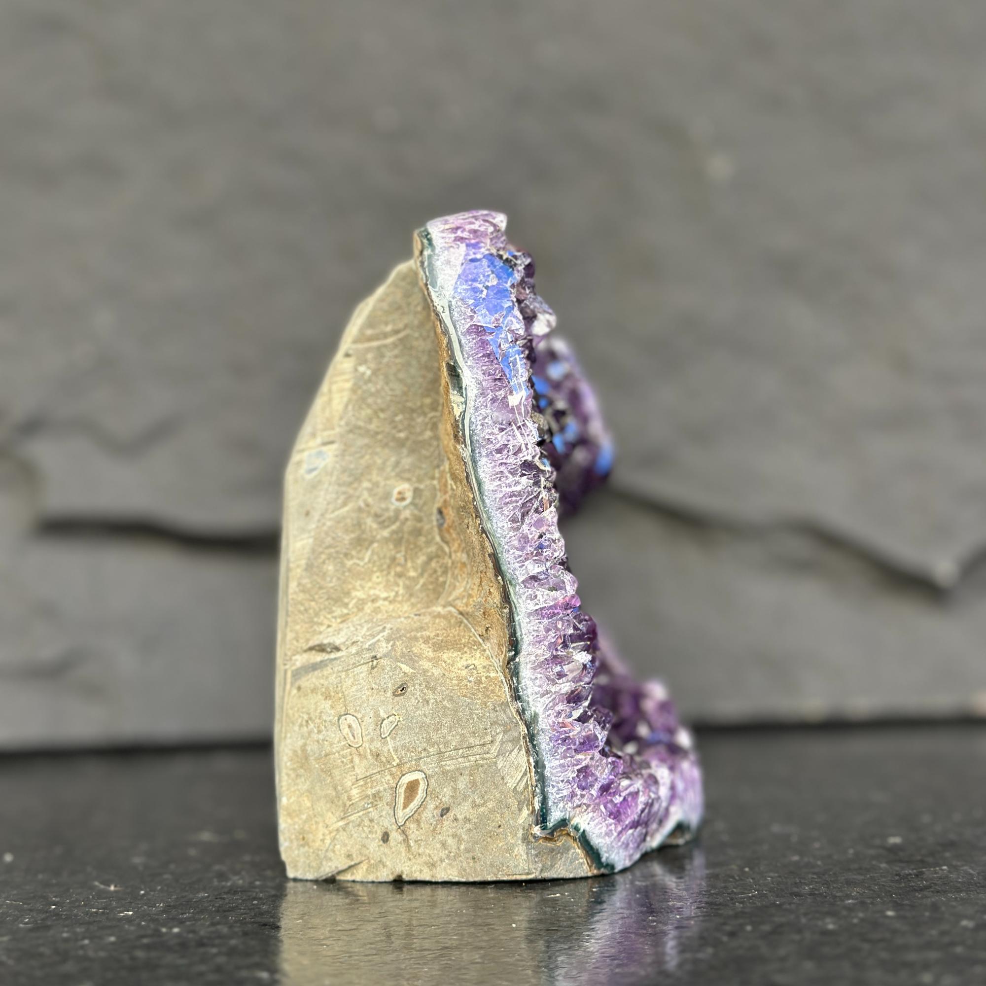 Mineral specimen with purple interior on a dark surface