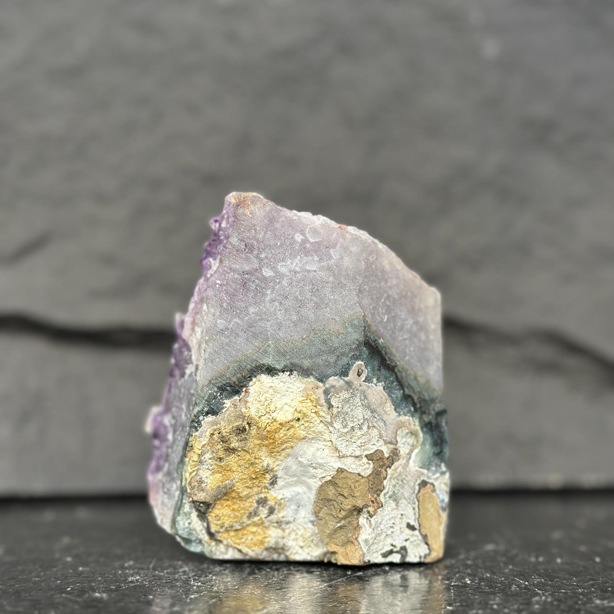 Mineral specimen with purple and gold colors on a dark background