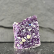 Amethyst crystal with small crystals on a dark gray background
