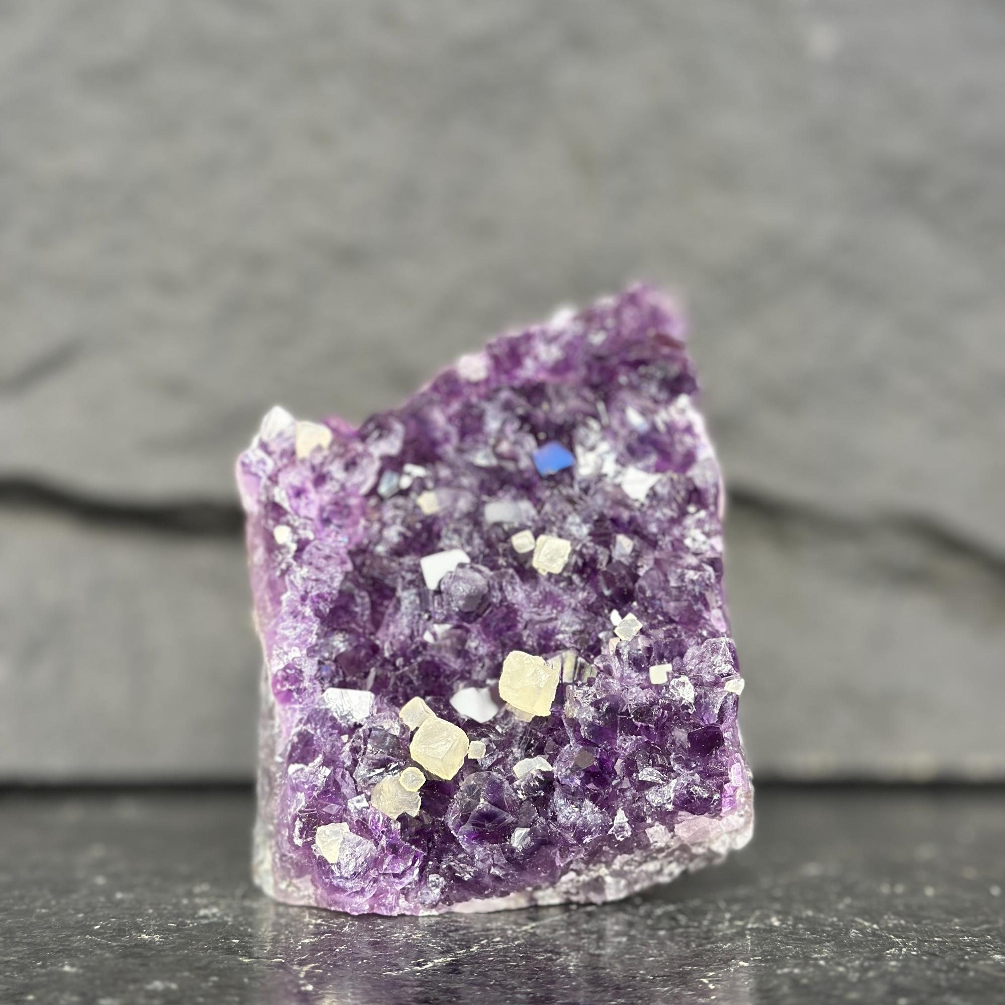 Amethyst crystal with small crystals on a dark gray background