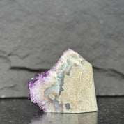 Mineral specimen with purple and white colors on a dark background