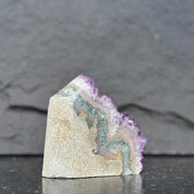 Geode crystal with purple and green colors on a dark background