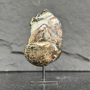 Mineral sample on a stand against a dark background