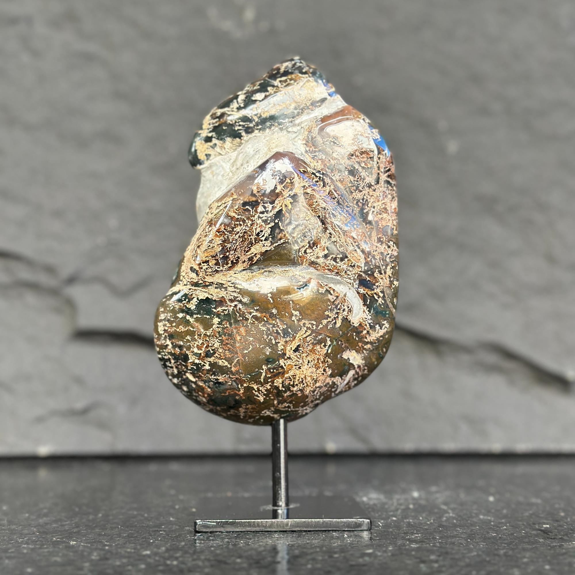 Mineral sample on a stand against a dark background