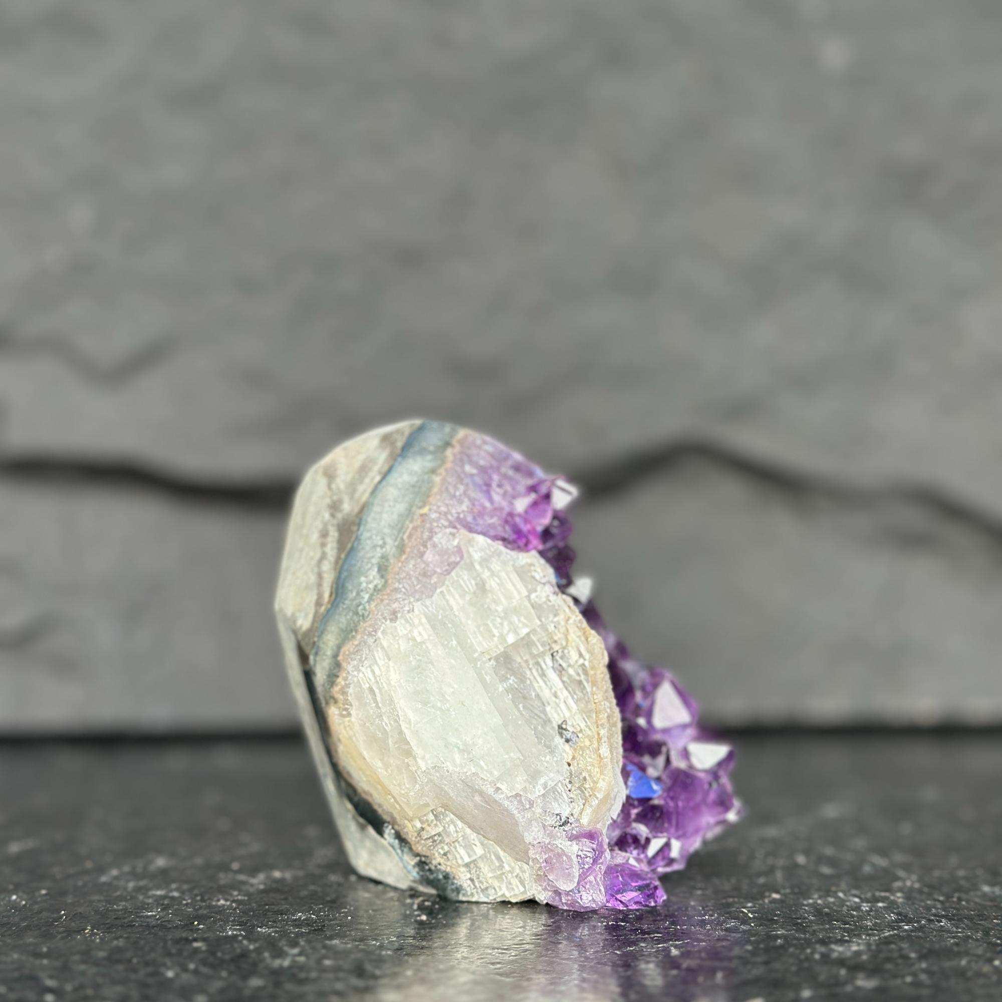 Crystal with purple and white colors on a dark surface