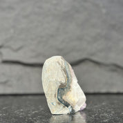 Unpolished crystal on a dark slate background