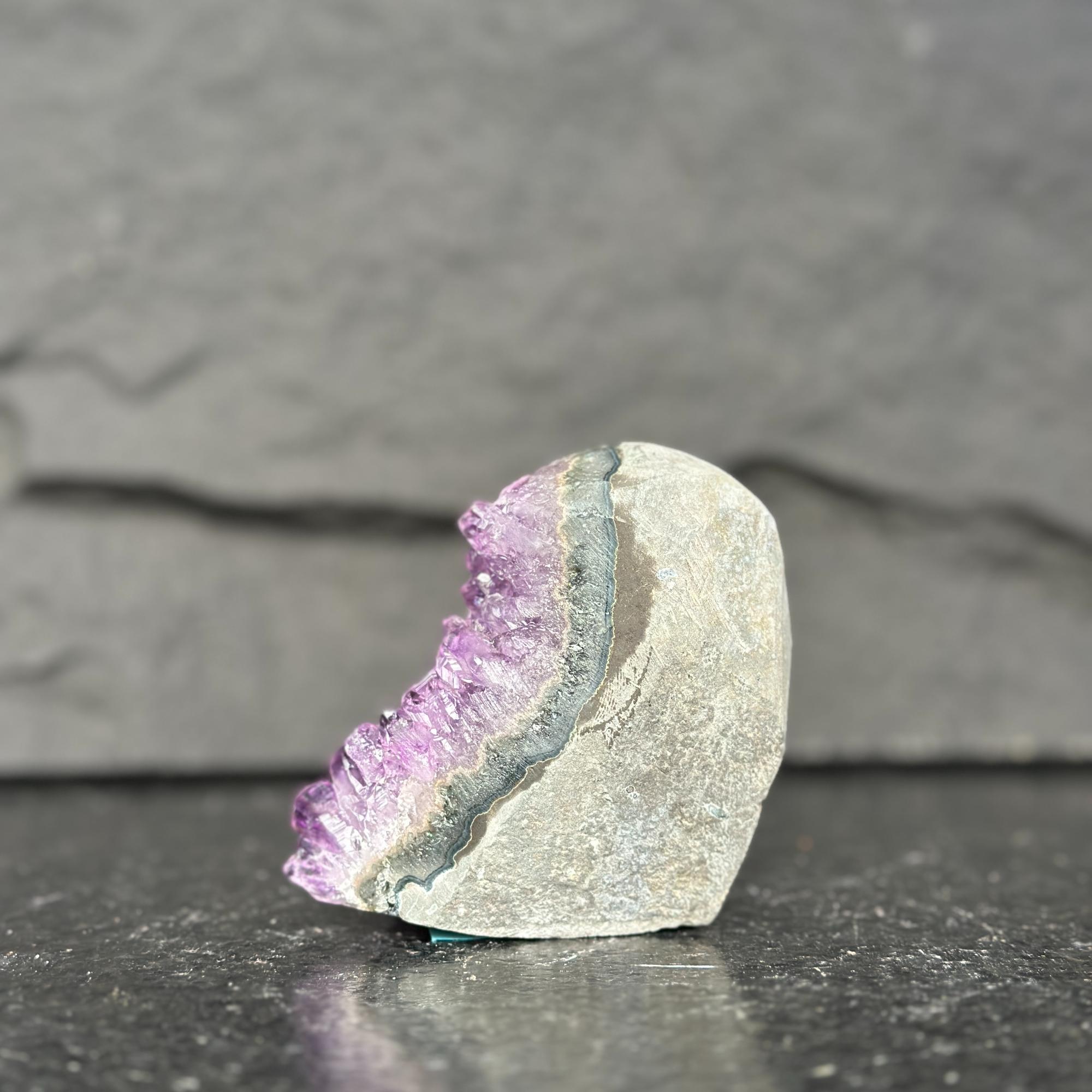 Crystal with purple interior on a dark surface