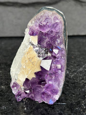 Amethyst crystal cluster on a dark surface