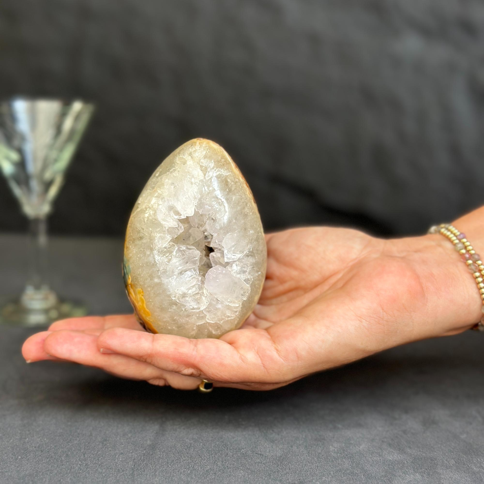 Hand holding a large crystal geode with a blurred background