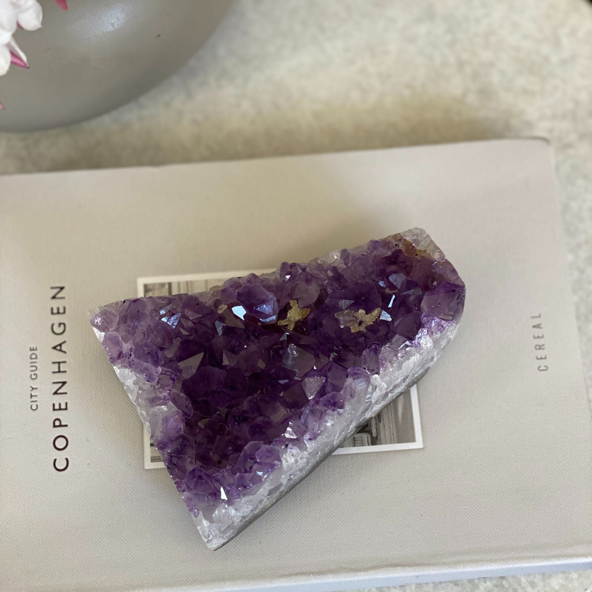 Deep purple flat amethyst crystal cluster, 4-inch tall, 1.2 lb, on a light book.
