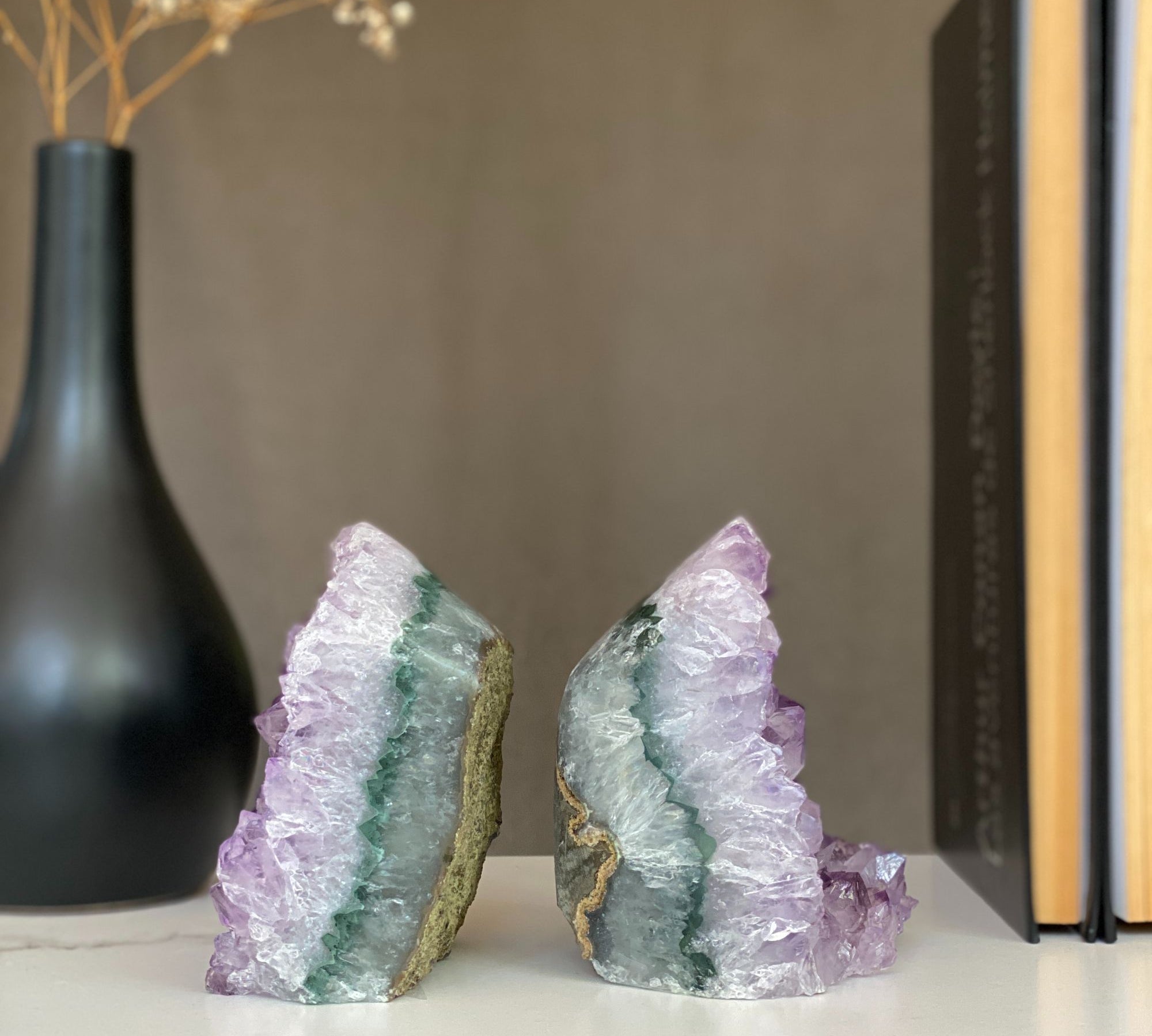 Pair of raw amethyst crystal bookends with sparkling purple points and green-gray agate bands.