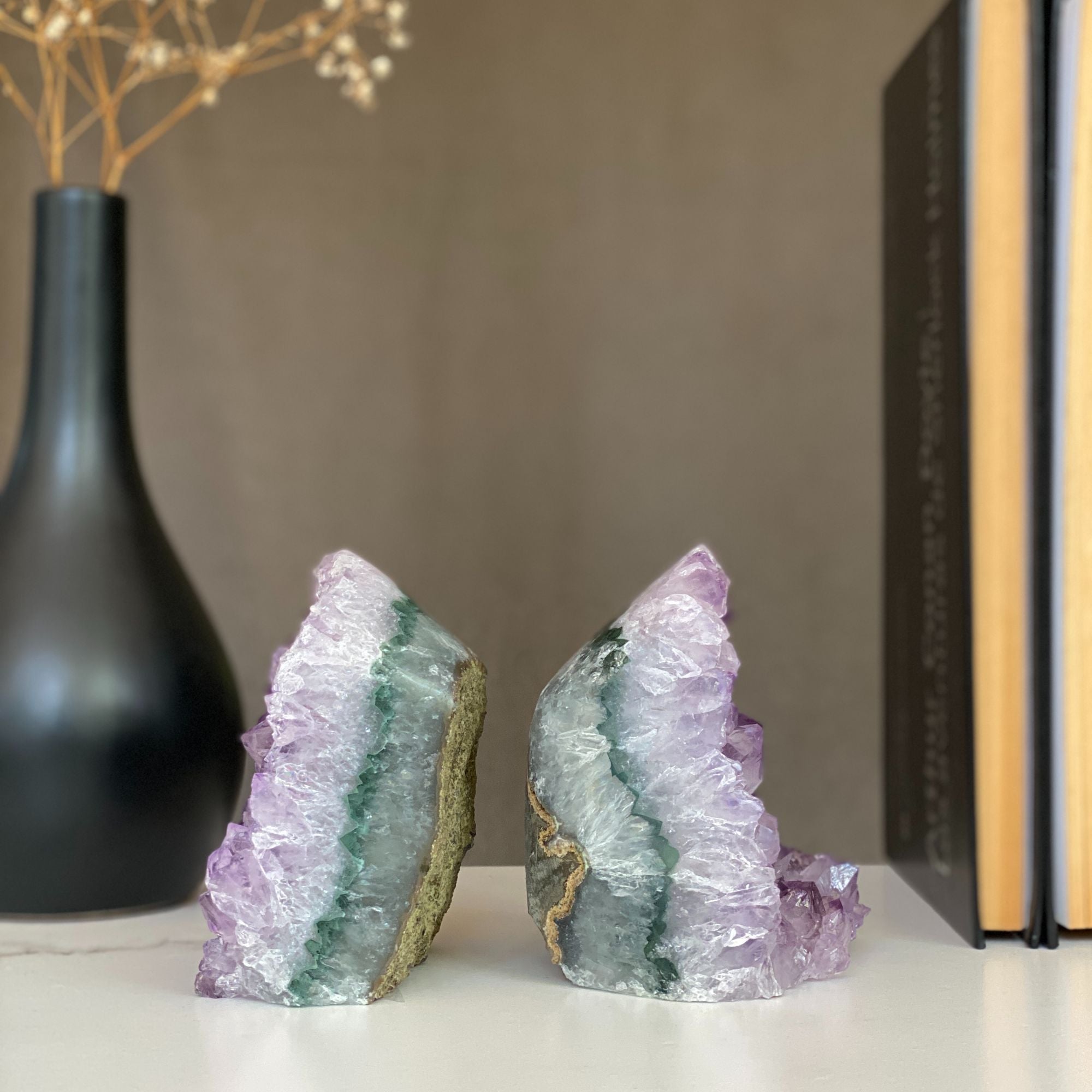 Pair of raw amethyst crystal bookends with sparkling purple points and green-gray agate bands.