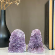 Two vibrant purple amethyst crystal clusters with natural green and gray agate bands, displayed as bookends.