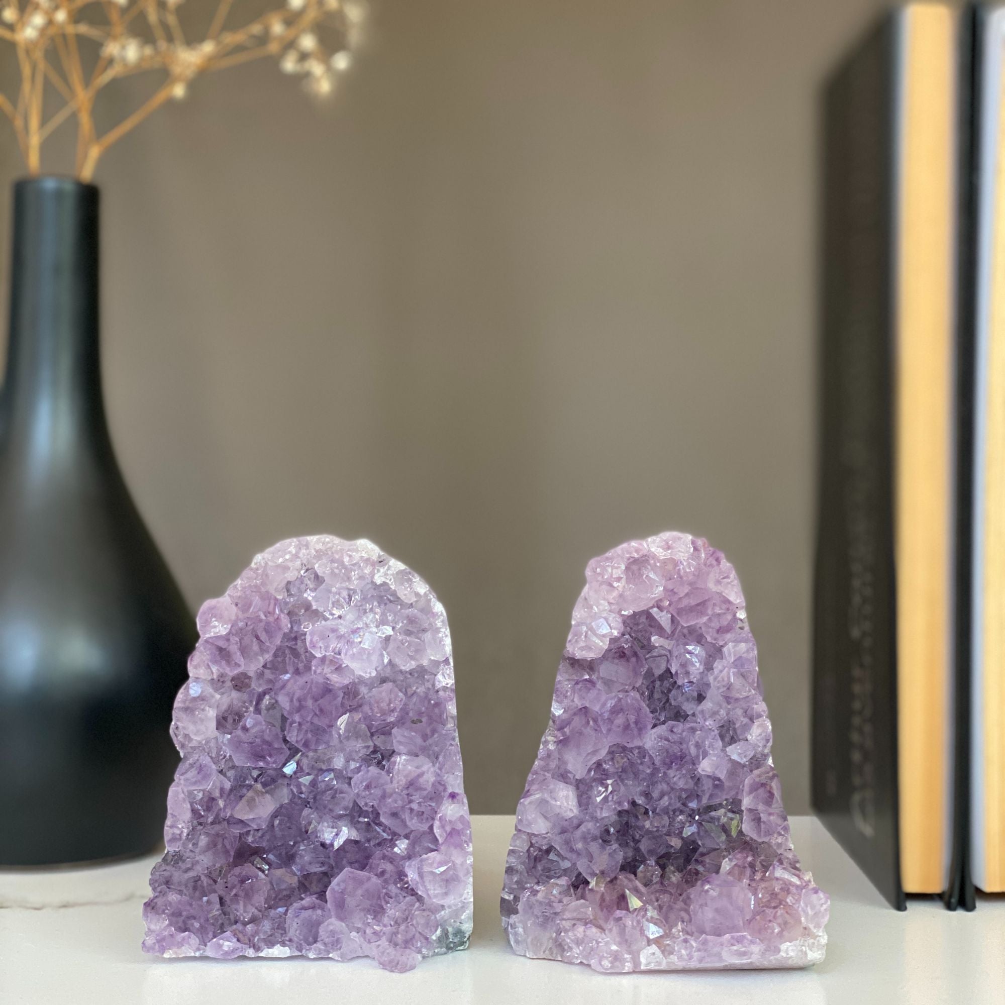 Two vibrant purple amethyst crystal clusters with natural green and gray agate bands, displayed as bookends.